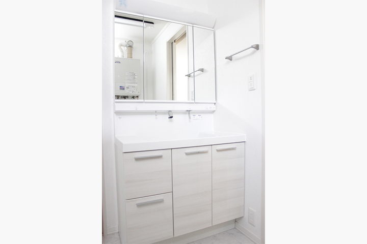 ホワイトカラーで統一した清潔感のあるワイドタイプの洗面所。